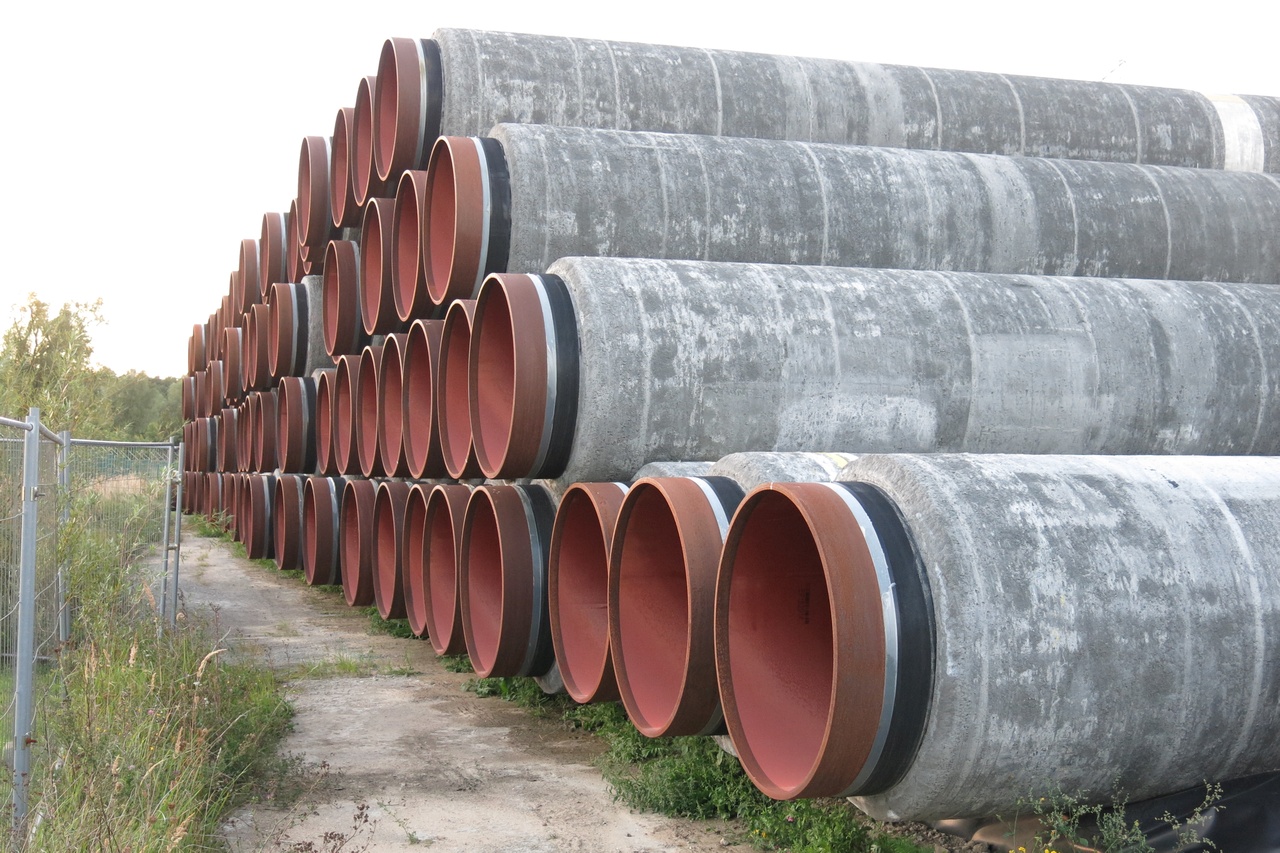 Stack of large-diameter coated steel line pipes stored at an industrial yard